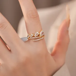 Detailweergave van een elegante vergulde open ring met drie peervormige zirkoniasteentjes.