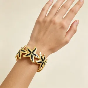 Statement Gold-Seestern-Manschettenarmband mit schwarzem Emaille am Handgelenk