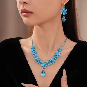 Primo piano di un'elegante collana di fiori in zircone blu e orecchini a goccia coordinati