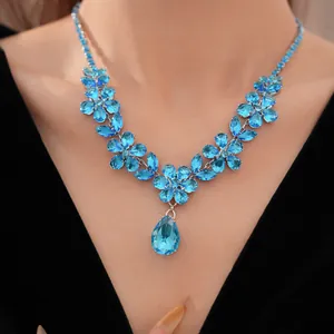 Dettaglio di un elegante collana in zircone blu con ciondolo a goccia sulla modella