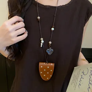 Detailed shot of polka dot leather magnetic glasses clip necklace worn on a model.