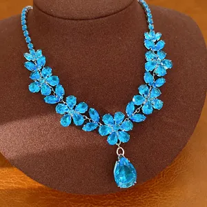 Vista dettagliata della collana a fiori in zirconia blu con elegante pendente a goccia.