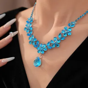 Primo piano di una collana a fiori in zircone blu con un grande ciondolo a goccia.