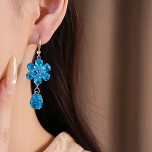 Vista dettagliata di eleganti orecchini a fiore e goccia in zirconia blu su una modella