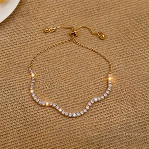 Detailaufnahme der pavé-gefassten Kristalle auf dem eleganten, wellenförmigen Goldarmband.