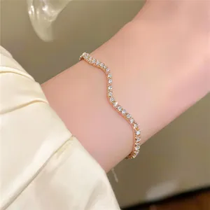 Detailansicht eines eleganten goldenen Wellenarmbands mit funkelnden Kristallen