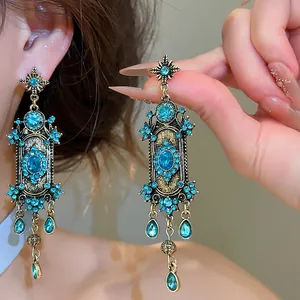 Detailopname van vintage paleisstijl oorbellen met blauwgroene strassteentjes en hangers