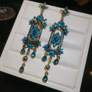 Gedetailleerde macro-opname van vintage gouden oorbellen met blauwe steentjes en luxe.