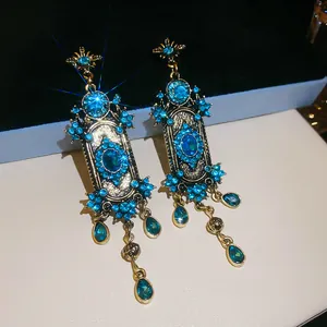Detail van vintage paleisstijl oorbellen met blauwe strassteentjes en druppelkristal