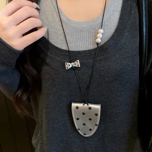 Detail of gray polka dot leather magnetic glasses clip necklace with bow and pearls