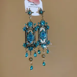 Detailweergave van vintage bungelende oorbellen in hofstijl met blauwe stras en druppels