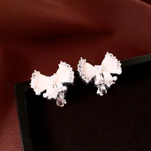 Nahaufnahme von Schleifen-Ohrclips mit Zirkon- und Perlendetails
