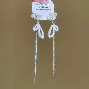 Vue détaillée de boucles d'oreilles papillon en argent avec motifs dentelle.