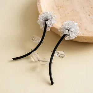 Détail de boucles d'oreilles fleurs artistiques avec cordon en cuir noir et cristaux
