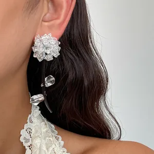 Gros plan détaillé d'une boucle d'oreille fleur en verre avec cordon noir sur un modèle