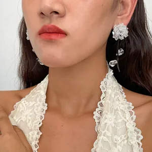 Gros plan de boucles d'oreilles fleur élégantes avec pétales en verre et cuir noir.