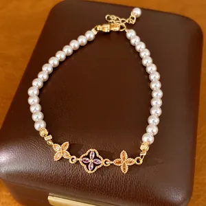 Detailopname van elegante 18K vergulde parelarmband met zirkoon bloembedeltjes
