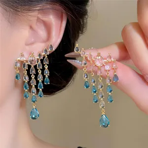 Detailed close-up of sparkling blue zircon water drop tassel earrings worn on ear