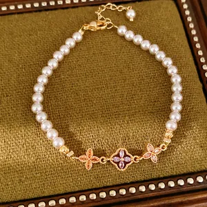 Elegante parelarmband met 18K vergulde zirkonia bloembedels op een groene achtergrond.
