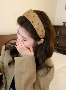 Model draagt een Koreaanse stijl brede kaki hoofdband versierd met sterrenstuds