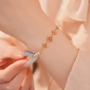 Gedetailleerde opname van een elegante 18k vergulde bloem parelarmband om de pols gedragen
