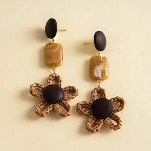Detailansicht von Vintage-Ohrringen aus Harz und gewebten Seilblumen.