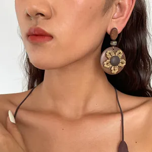 Nahaufnahme von Retro-Ohrringen aus Harz mit geflochtener Blume im Ethno-Stil