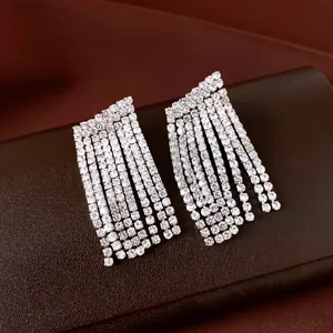 Close-up van elegante zilveren kwastjes oorbellen met fonkelende strassteentjes