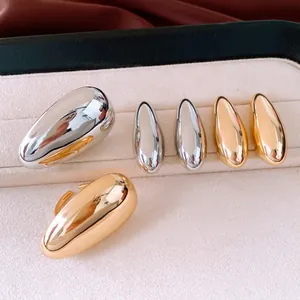 Nahaufnahme von glatten ovalen Ohrsteckern und Ring-Sets in Gold und Silber im Etui.