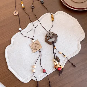 Detailansicht der Ethno-Halskette mit Holzperlen und Kokosnussschalen-Blumenanhänger.