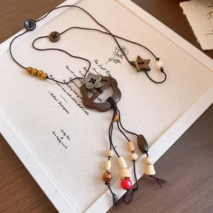 Detaillierte Ansicht einer ethnischen Holzkette mit Kokosnussschalen-Blumenanhänger.