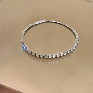 Detail shot of a silver stretch bracelet with sparkling crystals on a reflective surface
