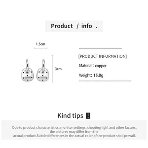 Vue détaillée des boucles d'oreilles argentées à pois avec détails des matériaux.