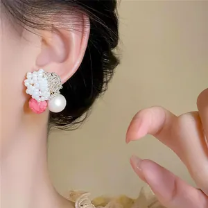 Detailed view showing the elegant S925 silver needle beaded pearl stud earrings on a model.