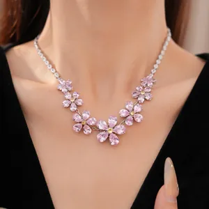 Detailed close-up showing an elegant pink zircon flower necklace worn on a model's neck