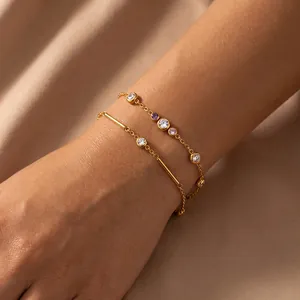 Elegante gouden roestvrijstalen armbanden met gekleurde zirkonia-stenen op de pols