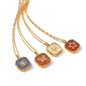 Detail view of four square gold-plated pendants with sun, butterfly, star, and starfish motifs.