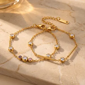 Detailopname van elegante gouden roestvrijstalen armbanden met fonkelende zirkonia