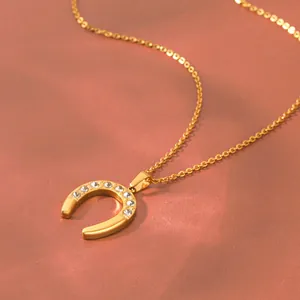 Close-up detail of a vintage gold-toned horseshoe necklace with sparkling crystal inlay