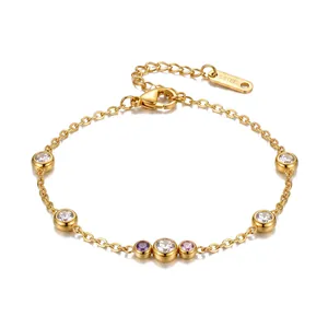 Detailopname van een goudkleurige stalen armband met ronde gekleurde zirkonia-steentjes.