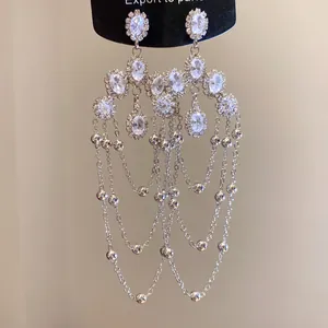Detailed macro view of elegant silver tassel earrings featuring sparkling clear crystals