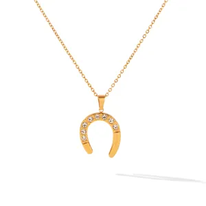 Close-up of a vintage horseshoe U-shaped pendant with sparkling rhinestones on a gold chain
