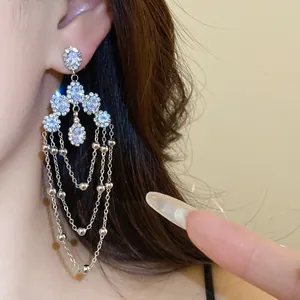 Close-up detail of luxury silver tassel earrings with sparkling zirconia stones for women