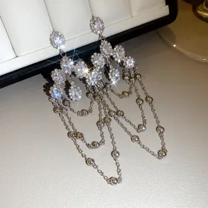 Detailed macro view of silver tassel earrings with sparkling oval and round crystals.