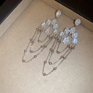 Close-up of elegant silver tassel earrings with shimmering crystals in a jewelry tray