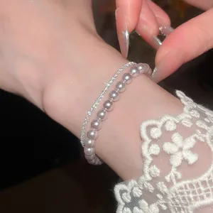 Nahaufnahme eines eleganten zweilagigen Armbands mit Perlen und funkelnden Zirkonen