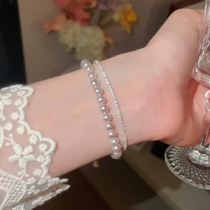 Elegantes zweilagiges Armband mit weißen Perlen und schimmernden Zirkonia-Akzenten.