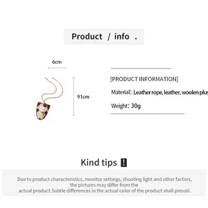 Gedetailleerde close-up van wollen schapenpop hanger ketting met afmetingen info.