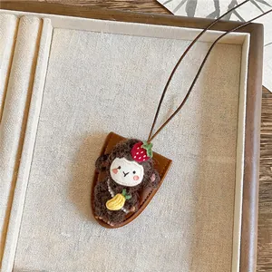 Detail van de handgemaakte pluchen schaap hanger met aardbeienhoed en lederen koord