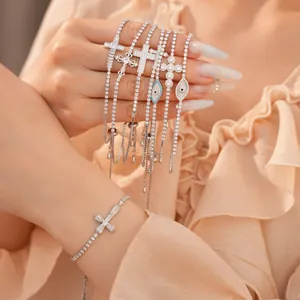 Detailopname van zirkonia armbanden met schelpoog en kruishangers voor dames